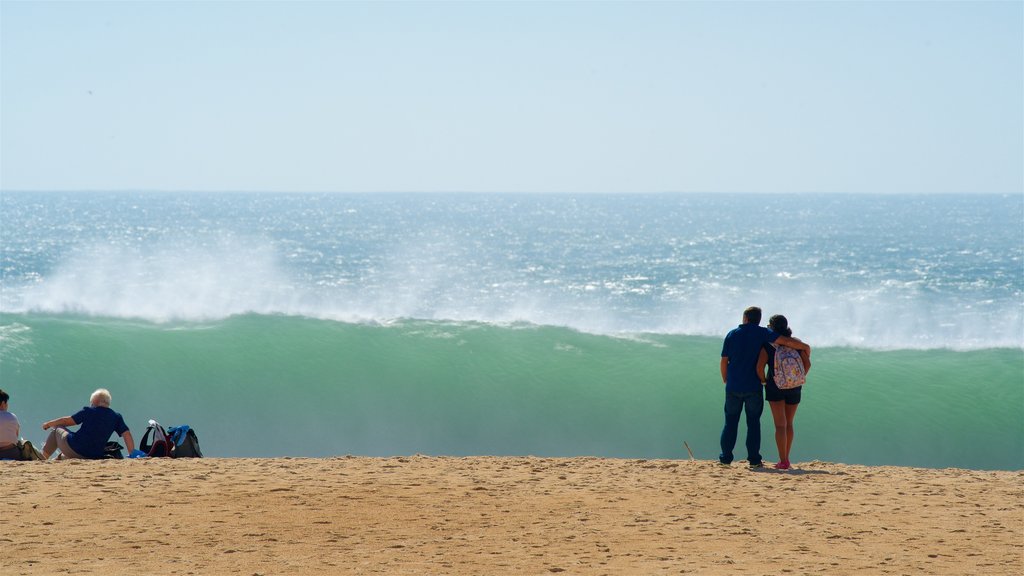 Nazare Beach which includes a sandy beach, general coastal views and waves