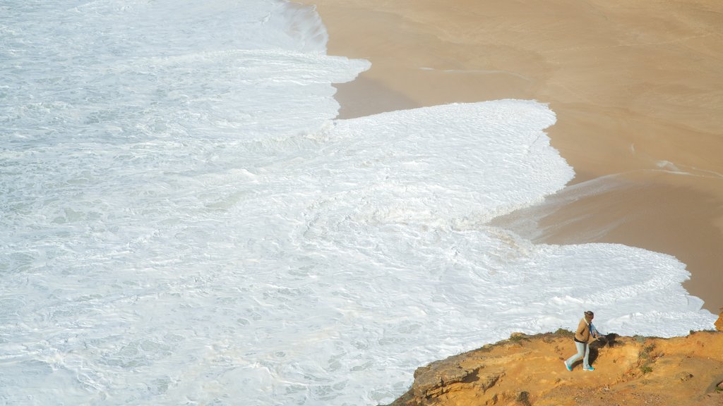 Norte Beach ofreciendo una playa de arena y vistas generales de la costa y también una mujer