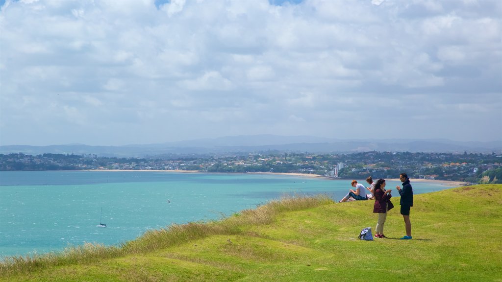 Mount Victoria ofreciendo vistas generales de la costa y un jardín y también un pequeño grupo de personas