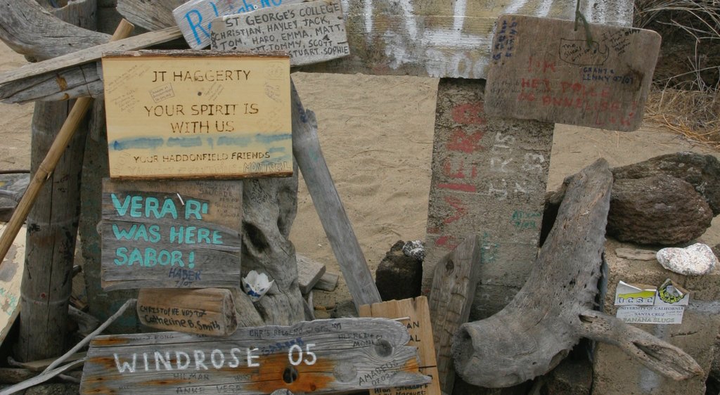 Floreana Island featuring a sandy beach, outdoor art and signage