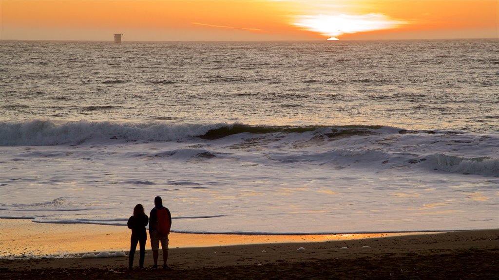 Baker Beach mostrando surfe, uma praia de areia e um pôr do sol