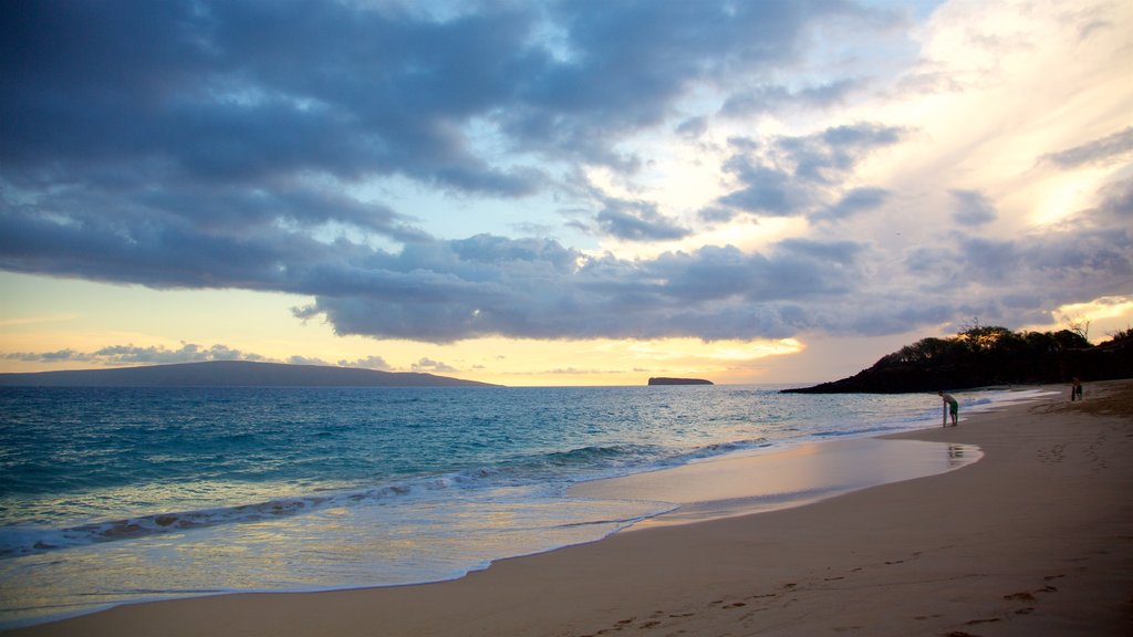 Makena Beach State Park som inkluderar en sandstrand, en solnedgång och kustutsikter