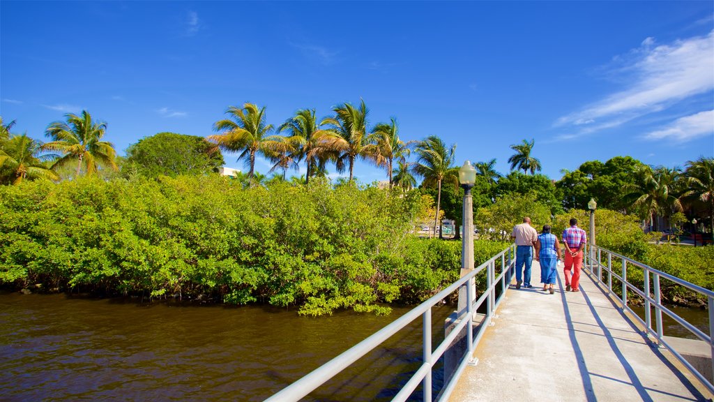 Centennial Park showing a bridge and a river or creek as well as a small group of people