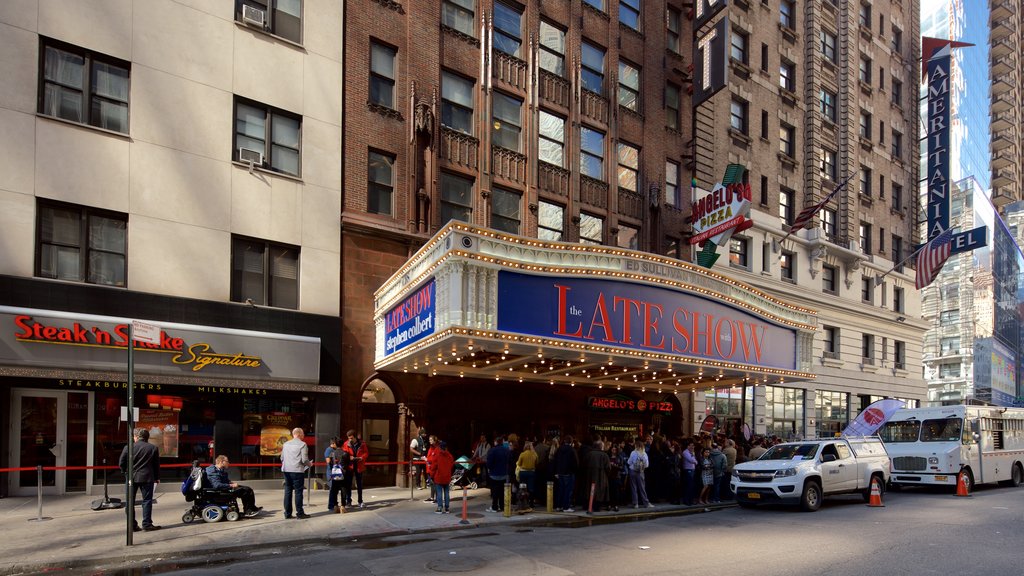 Ed Sullivan Theater which includes signage and a city as well as a large group of people