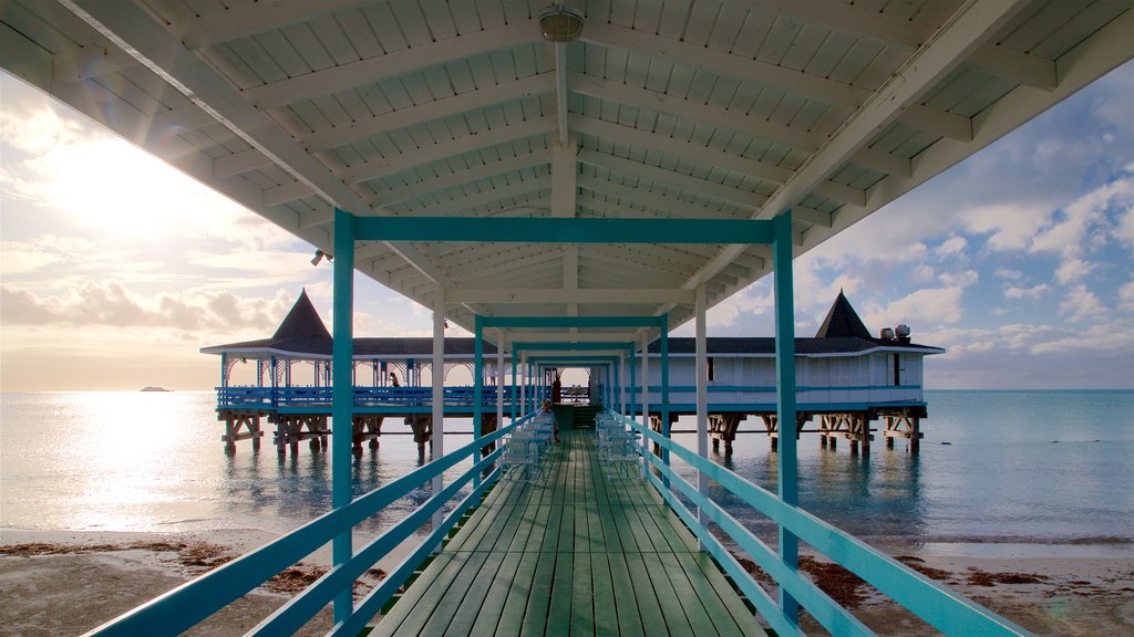 Dickenson Bay Beach which includes general coastal views, a sandy beach and a sunset