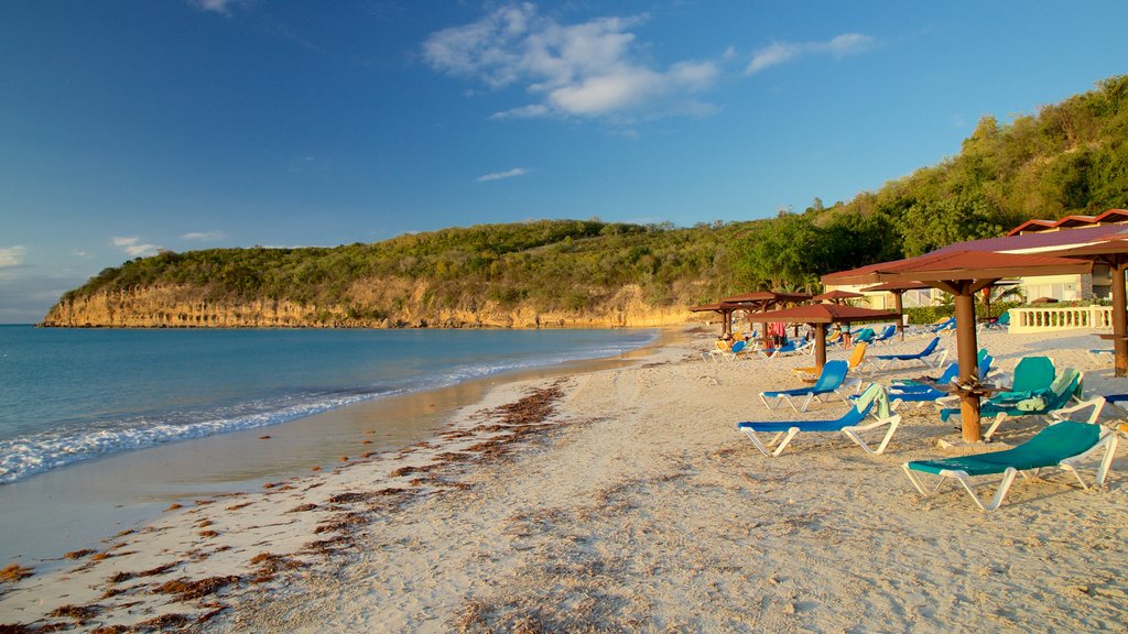 Dickenson Bay Beach showing rugged coastline, a sunset and a beach