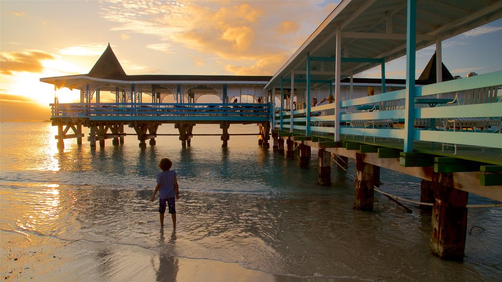 Dickenson Bay Beach which includes general coastal views, a sunset and a sandy beach