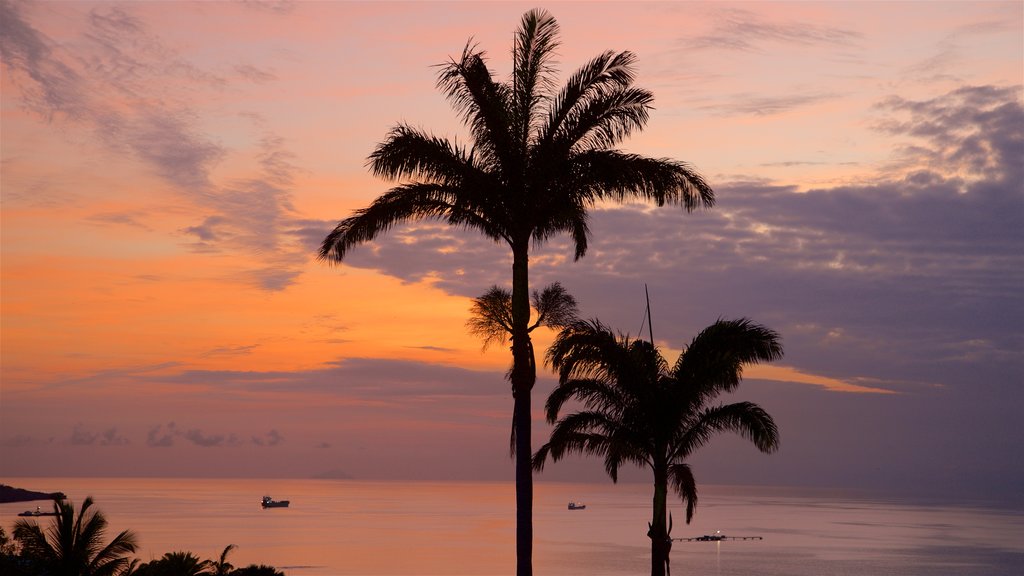 Dickenson Bay Beach ofreciendo una playa de arena, una puesta de sol y escenas tropicales