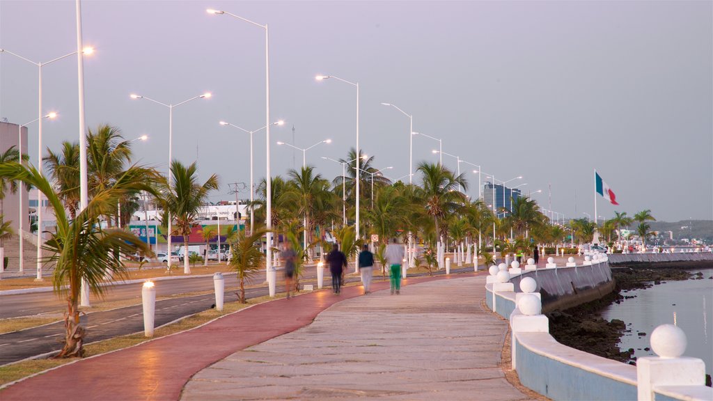 Promenade en bord de mer de Campeche mettant en vedette baie ou port aussi bien que petit groupe de personnes