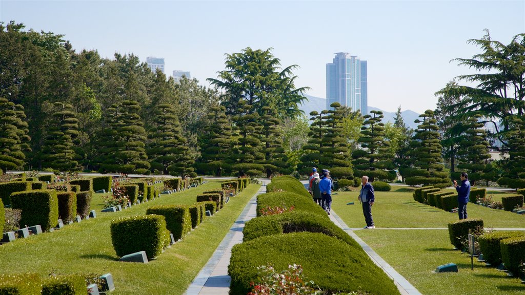 UN Memorial Cemetery featuring a skyscraper and a park as well as a small group of people