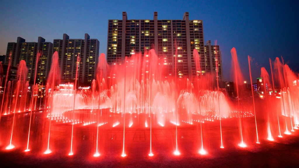 Fuente de los sueños del atardecer de Dadaepo que incluye escenas nocturnas, una ciudad y una fuente