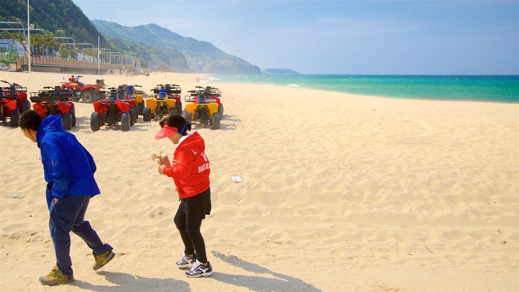 Jeongdongjin Beach showing general coastal views and a beach as well as a couple