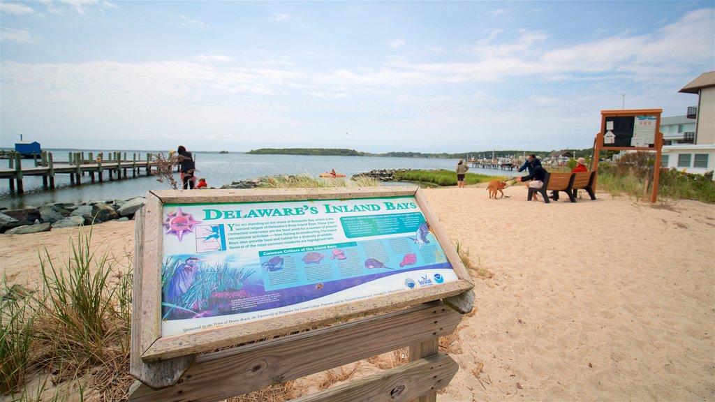 Dewey Beach showing signage, a sandy beach and general coastal views