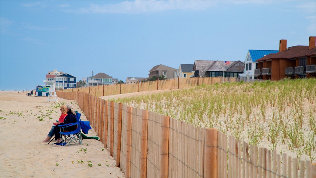 Dewey Beach ofreciendo vistas generales de la costa y una playa de arena y también una pareja