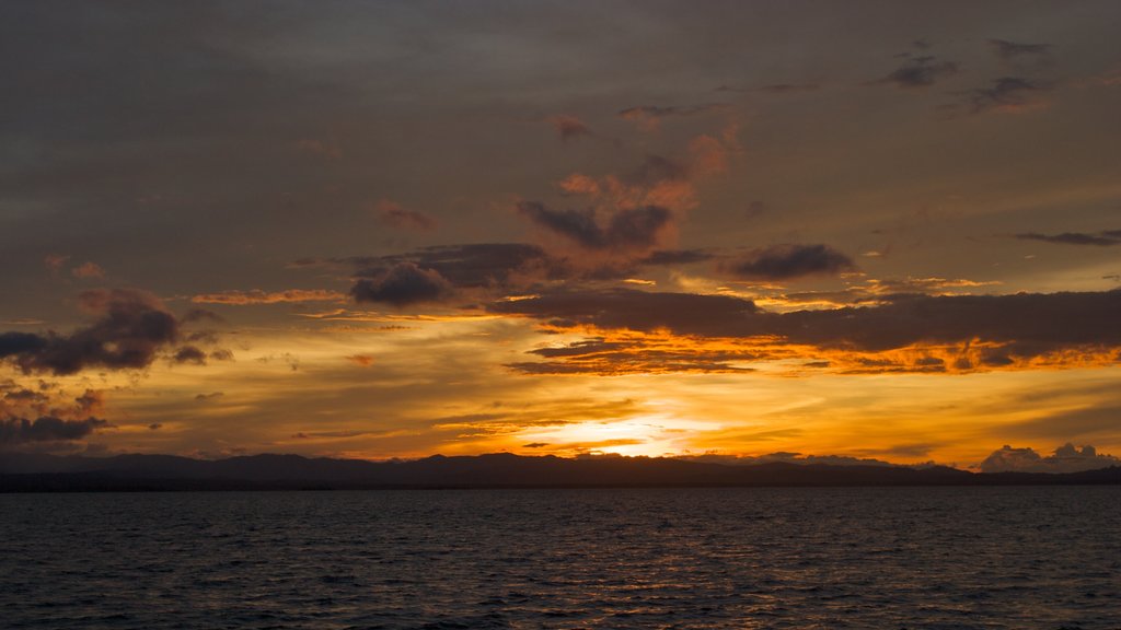 Panama showing a beach, a sunset and rocky coastline