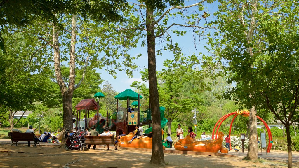 Yongsan Park showing a playground and a garden as well as a family