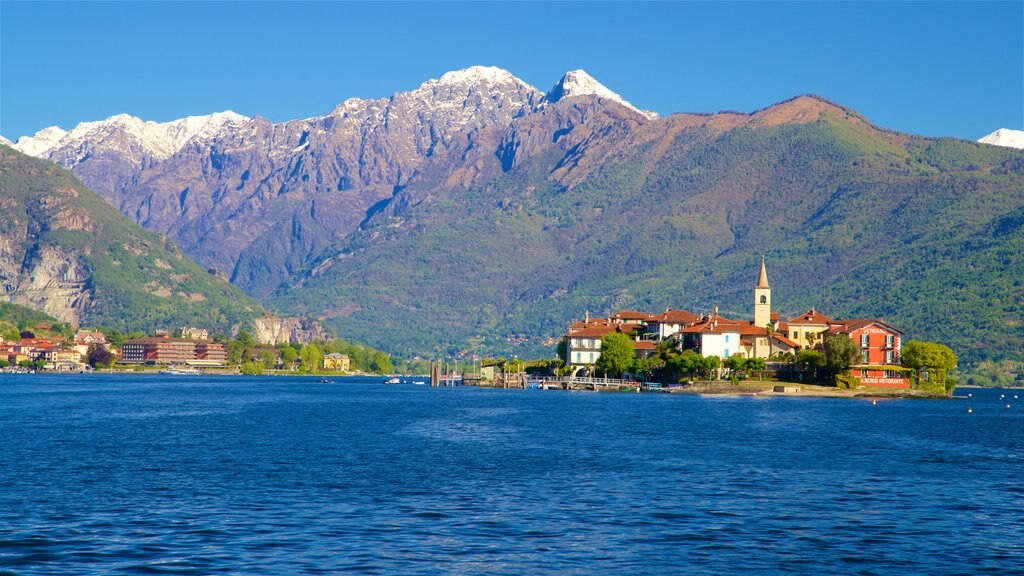 Isola dei Pescatori mostrando una pequeña ciudad o pueblo, montañas y un lago o abrevadero