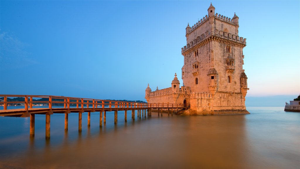 Torre de Belém caracterizando arquitetura de patrimônio, um lago ou charco e um pôr do sol