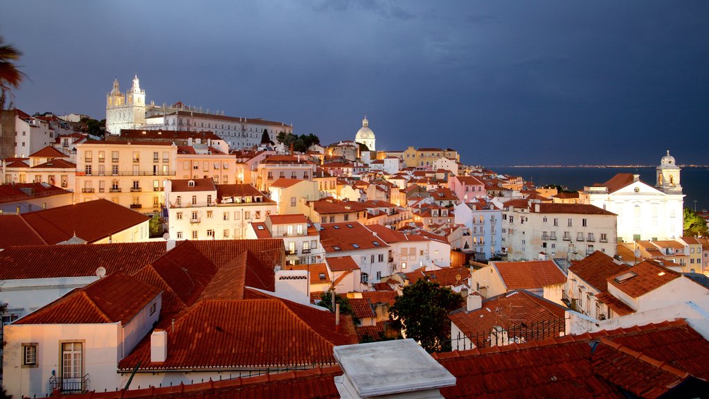 Miradouro de Santa Luzia showing a coastal town, night scenes and a city