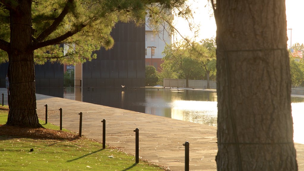 Oklahoma City National Memorial and Museum showing a sunset, a pond and a park