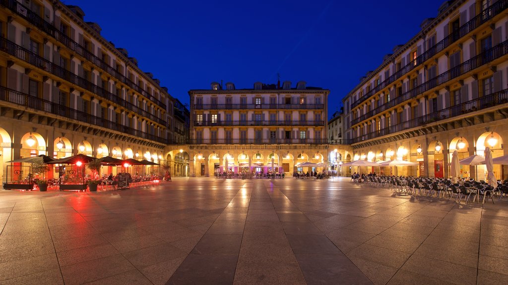 Plaza de La Constitucion que inclui cenas noturnas, uma praça ou plaza e elementos de patrimônio