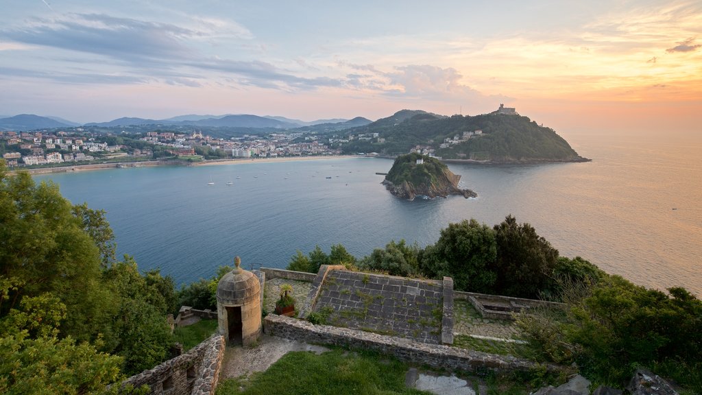 Monte Urgull which includes island views, a sunset and a coastal town