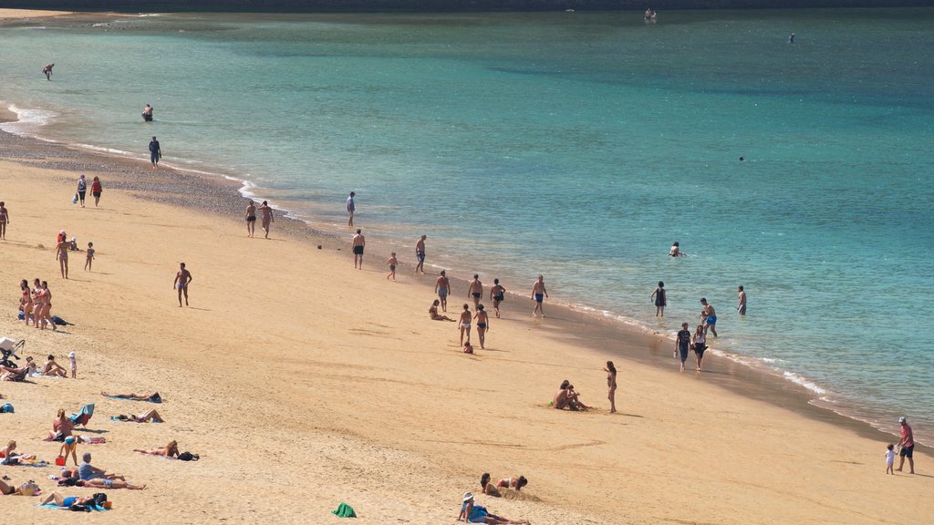 Ondarreta Beach showing a sandy beach and general coastal views as well as a large group of people