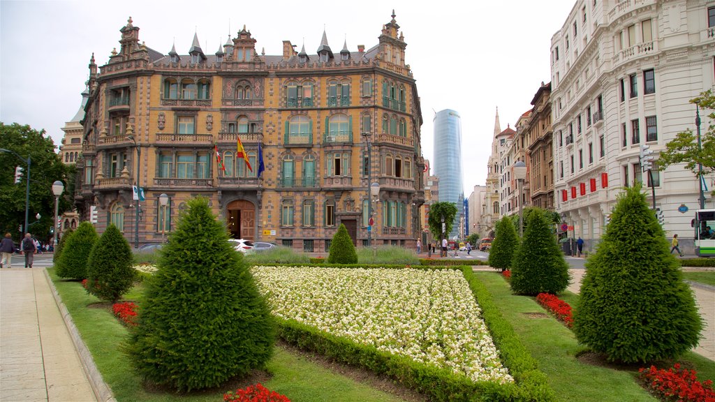 Plaza Moyua which includes a skyscraper, flowers and a garden