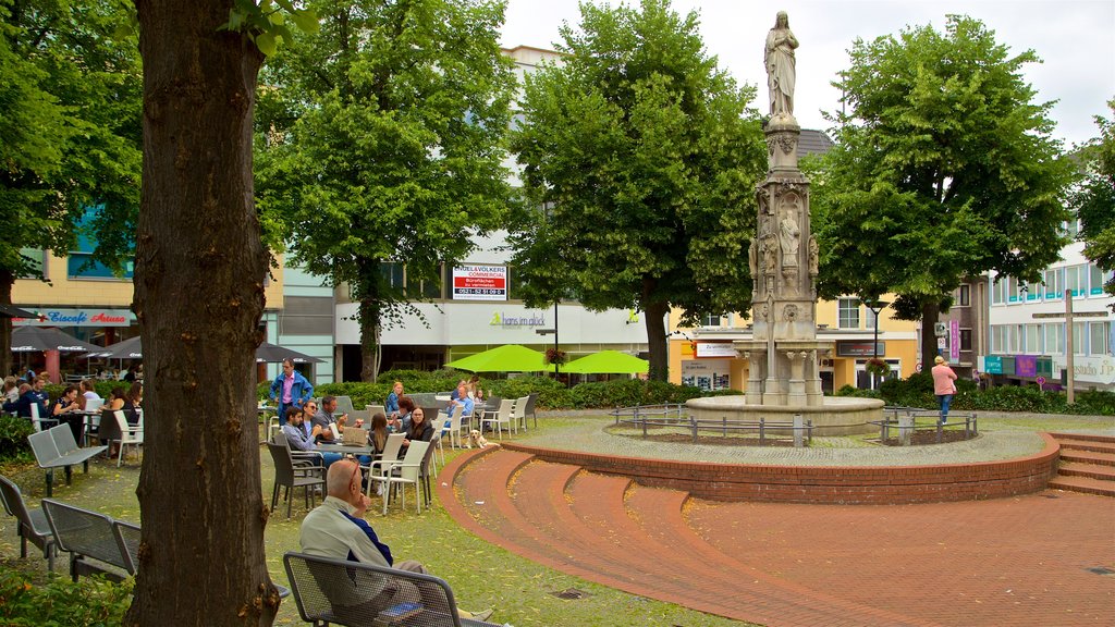 Marienplatz Paderborn showing a fountain and a statue or sculpture as well as a small group of people