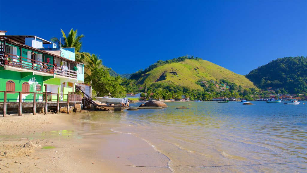 Enseada Beach which includes a coastal town, a sandy beach and general coastal views