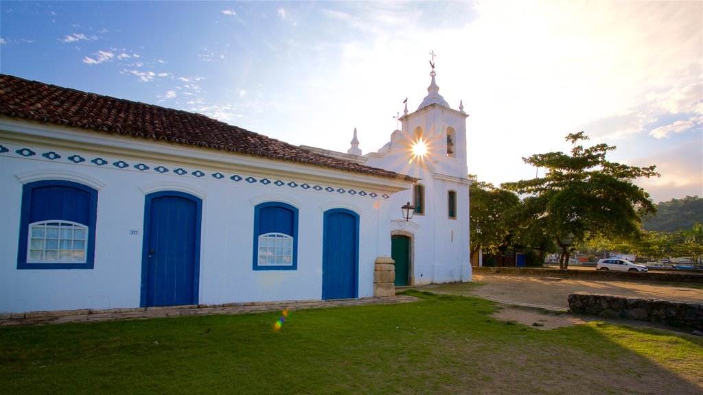 Iglesia Nossa Senhora das Dores que incluye una iglesia o catedral y una puesta de sol