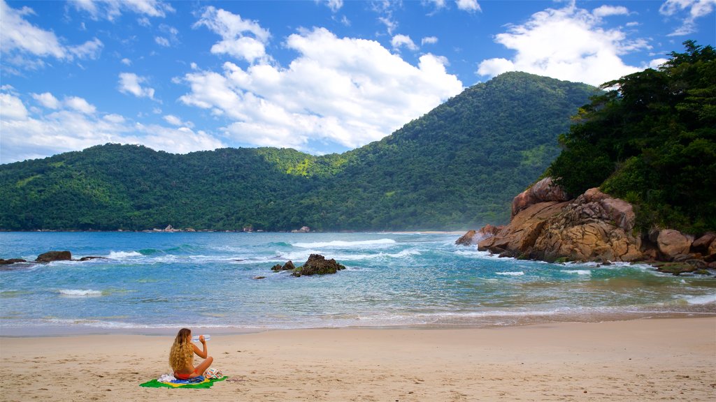 Meio Beach which includes general coastal views and a sandy beach as well as an individual female