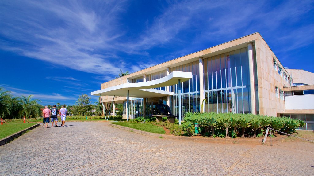 Pampulha Art Museum showing a park and modern architecture as well as a small group of people