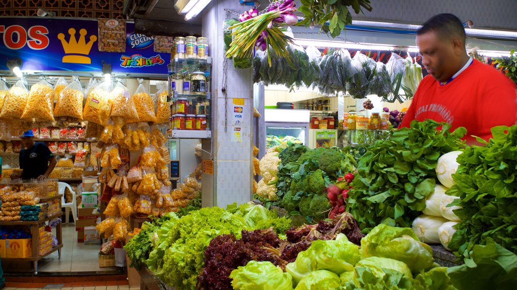 Mercado Central de Belo Horizonte mostrando mercados e comida assim como um homem sozinho