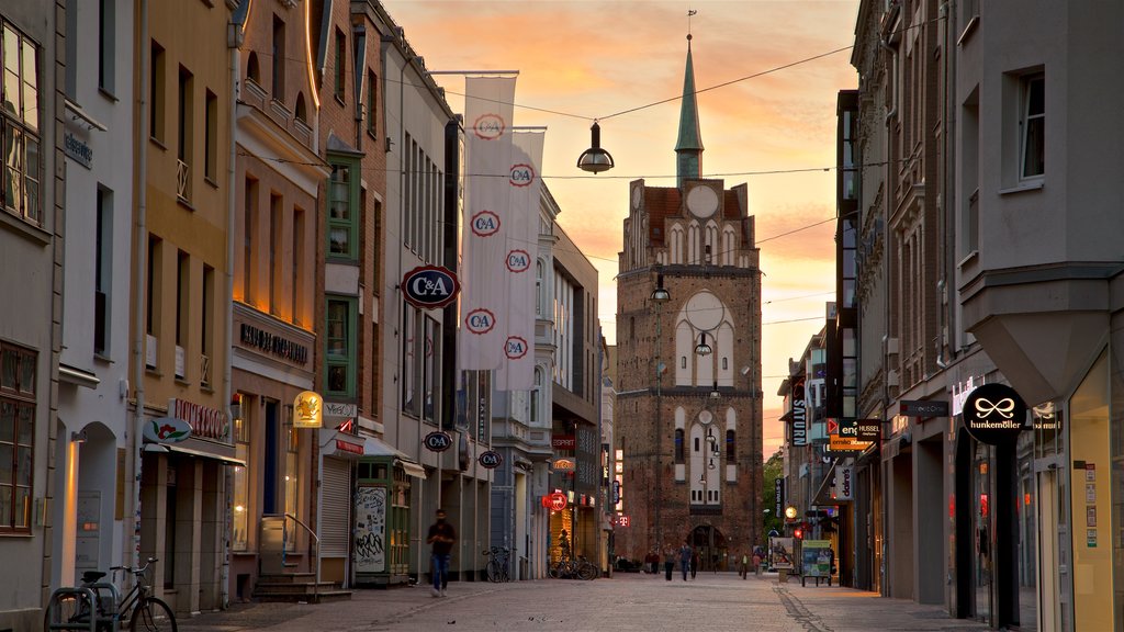 Kröpeliner Tor que inclui arquitetura de patrimônio, um pôr do sol e uma cidade