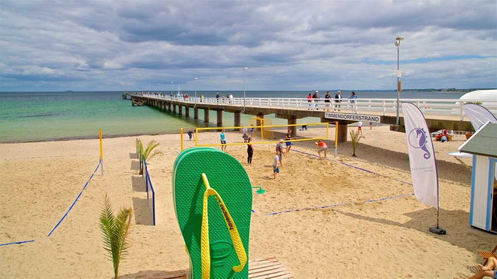 Timmendorfer Strand que incluye vistas generales de la costa y una playa de arena y también un pequeño grupo de personas