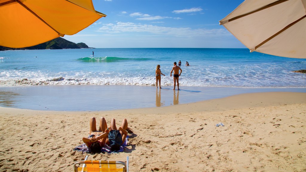 Playa Brava ofreciendo una playa de arena y vistas generales de la costa y también una pareja