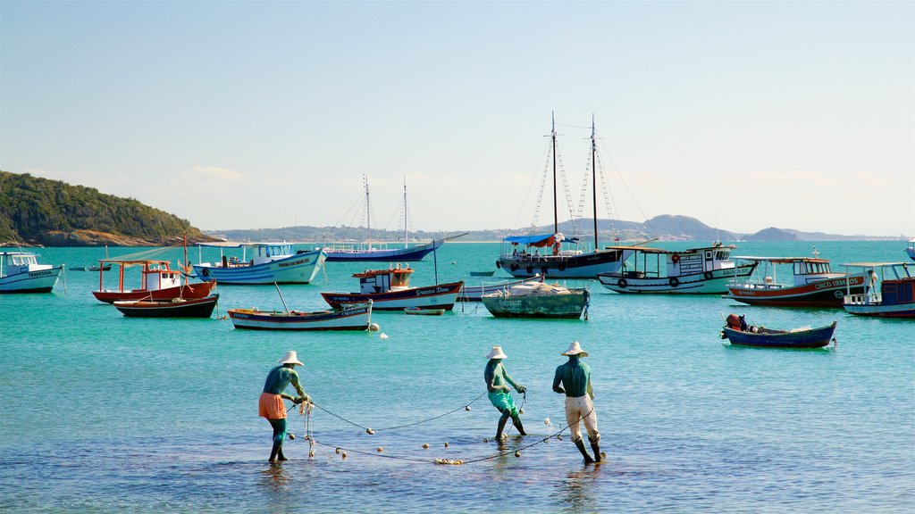 Praia da Armação mostrando uma baía ou porto assim como um pequeno grupo de pessoas