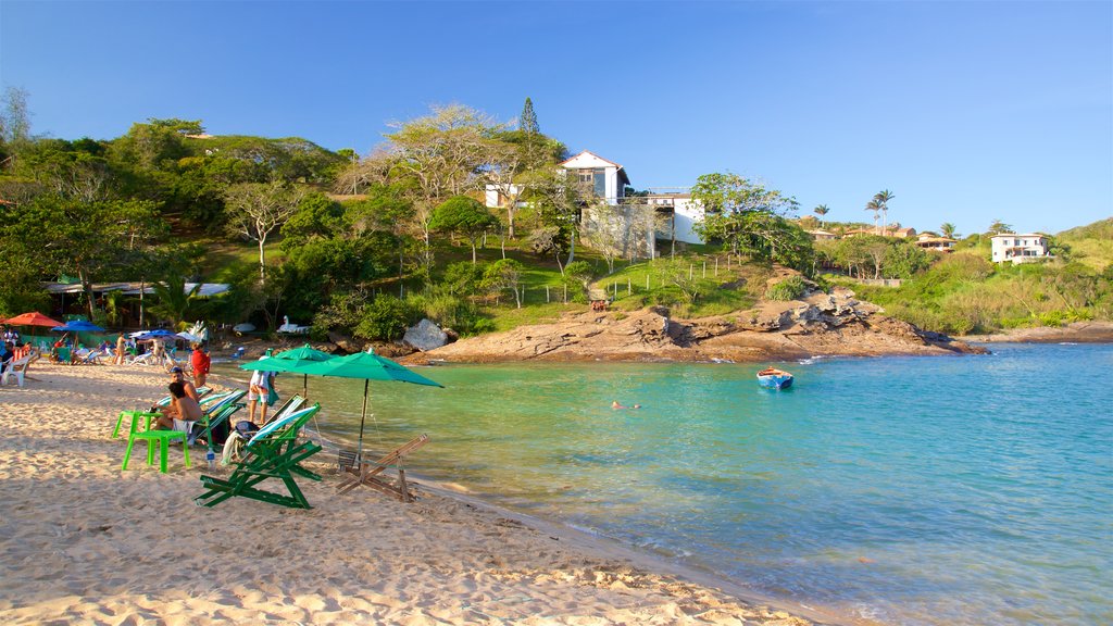 Playa Ferradura ofreciendo vistas generales de la costa y una playa de arena y también un pequeño grupo de personas