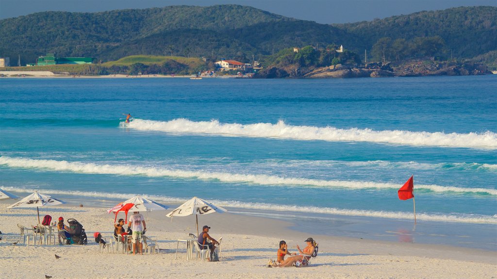 Playa de las Dunas que incluye una playa de arena y vistas generales de la costa y también un pequeño grupo de personas