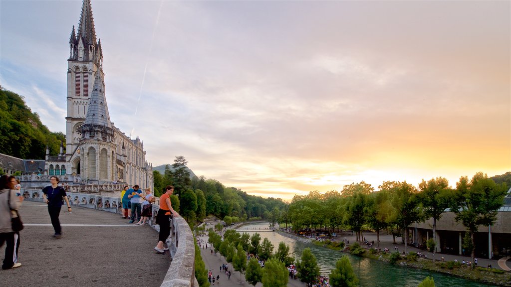 Notre-Dame de l\'Immaculee-Conception som omfatter en solnedgang, historiske bygningsværker og en flod eller et vandløb