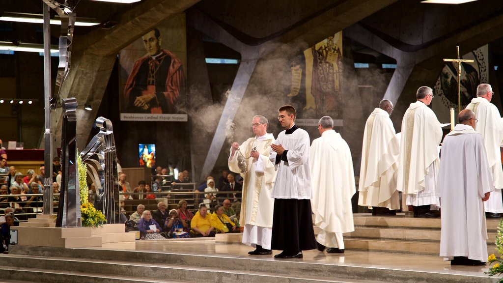 Basílica de San Pío X que incluye vista interna y una iglesia o catedral y también un pequeño grupo de personas