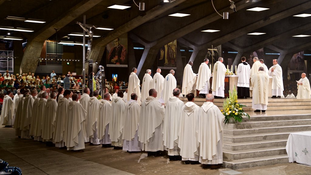 Basilica of St. Pius X showing interior views and a church or cathedral as well as a small group of people