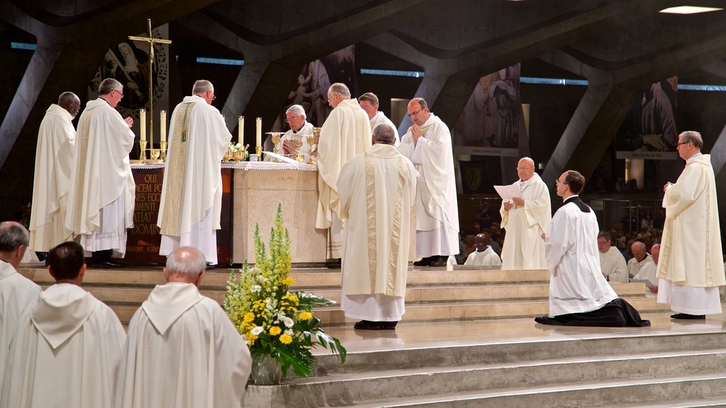 Saint Pius X Basilika og byder på interiør og en kirke eller en katedral såvel som en lille gruppe mennesker