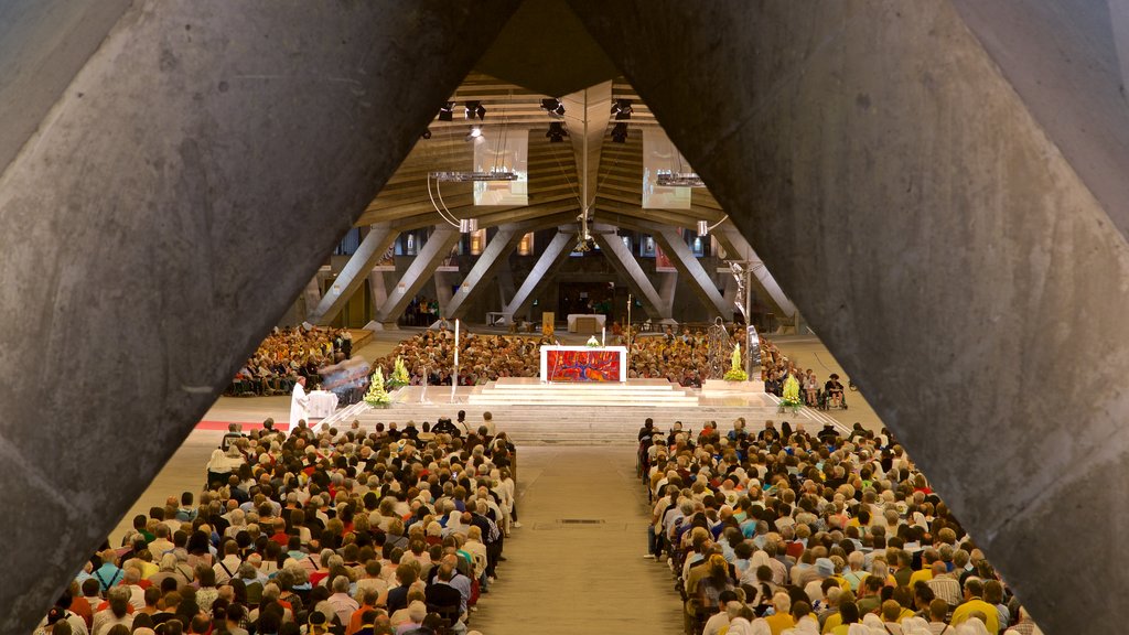 Basilica of St. Pius X which includes a church or cathedral and interior views as well as a large group of people