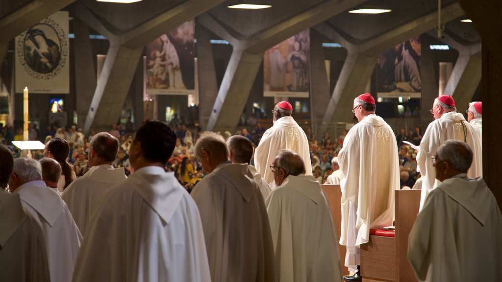 Basílica de San Pío X que incluye una iglesia o catedral y vista interna y también un pequeño grupo de personas