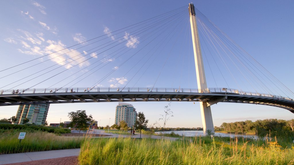 Puente peatonal Bob Kerrey ofreciendo un río o arroyo, un puente y un atardecer