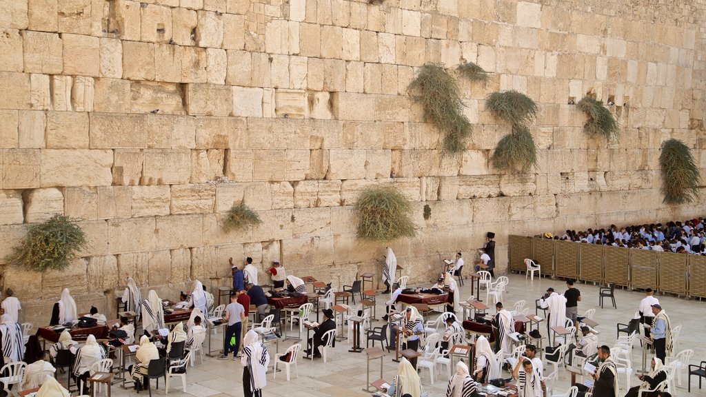 Western Wall showing religious aspects and heritage elements as well as a small group of people