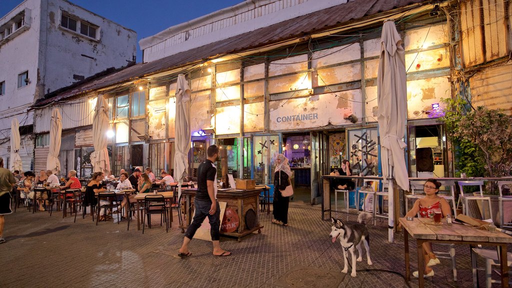 Porto de Jaffa mostrando cenas noturnas e jantar ao ar livre assim como um pequeno grupo de pessoas