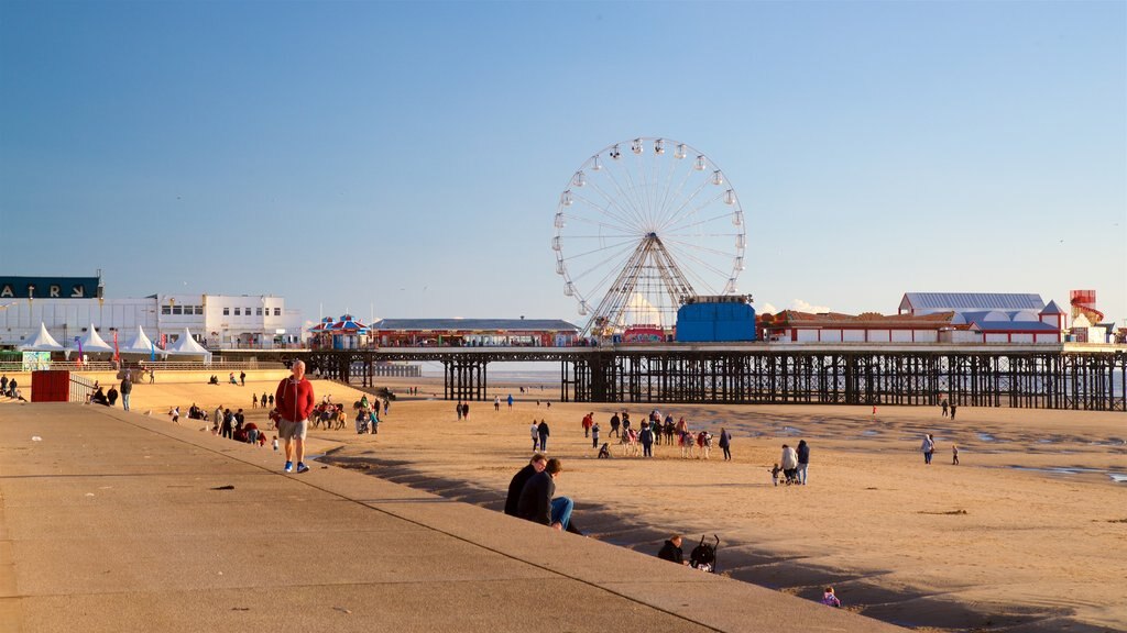 Playa de Blackpool que incluye vista general a la costa y una playa de arena y también un pequeño grupo de personas